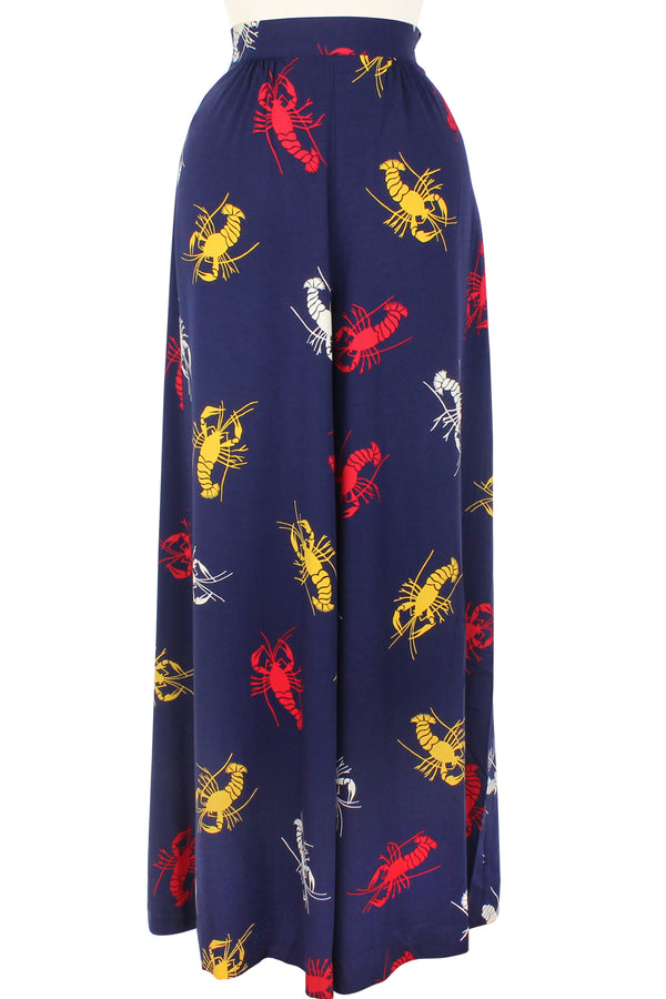 The vintage-inspired Belle Pants are a nod to 1940s lounge pants and pajamas sets that have carried through many eras featuring a high banded waist with very light gathering front and back and chic wide legs. Draped across the hips so plenty of room for curves in our 1930s 1940s Crawfish novelty print of red, yellow, and white crustaceans on a deep navy blue background.