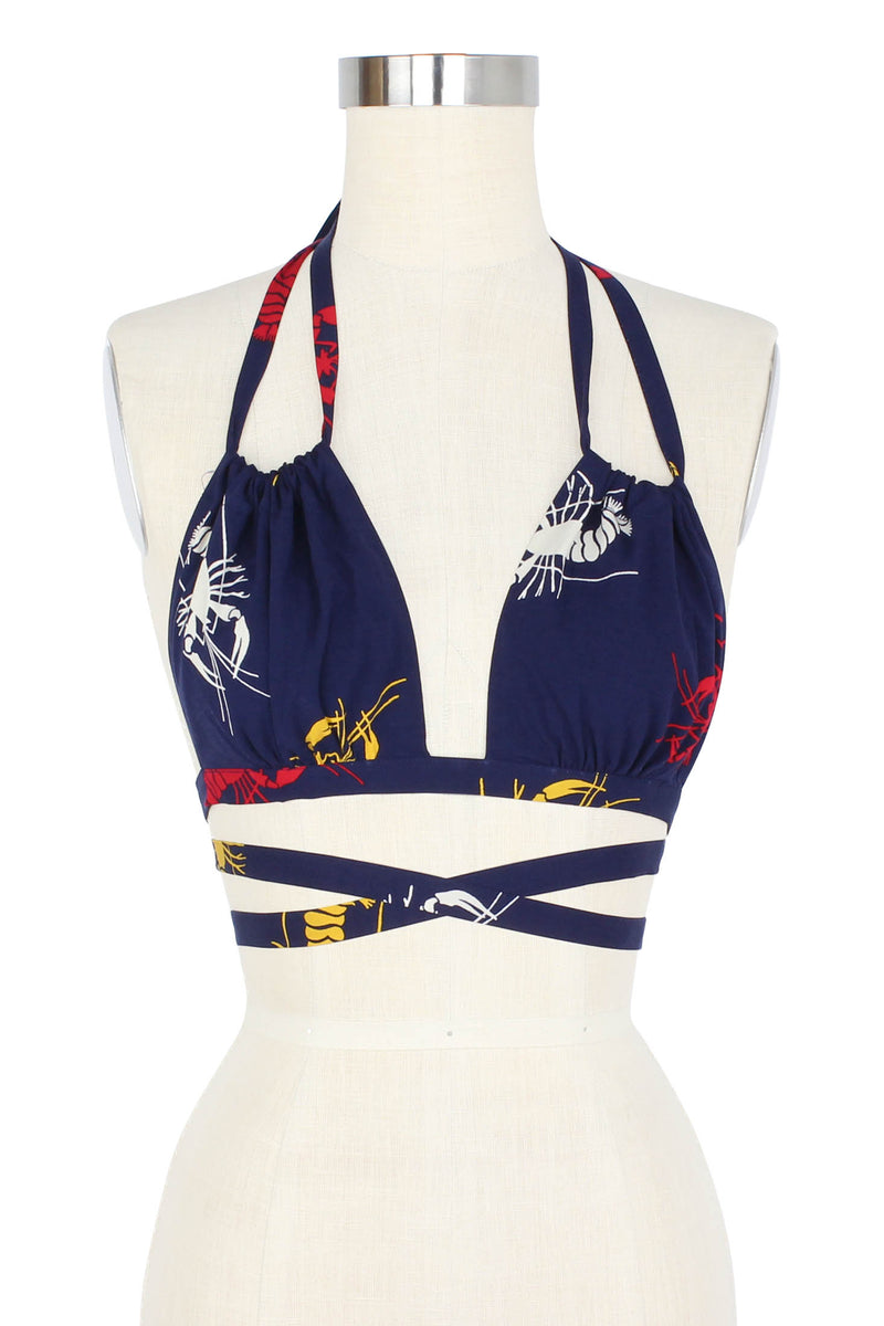 Named for 1940s swimmer Esther Williams, the Crawfish Esther Halter Top can be wrapped and tied a number of ways with its long adjustable straps. Make this adorable bikini top more modest by layering under the Freddy shirt or Heather Blazer in matching Crawfish print, a fun 1930s/40s novelty print of red, yellow, and white crustaceans on a deep navy blue background as a nod to Schiaparelli's lobster.