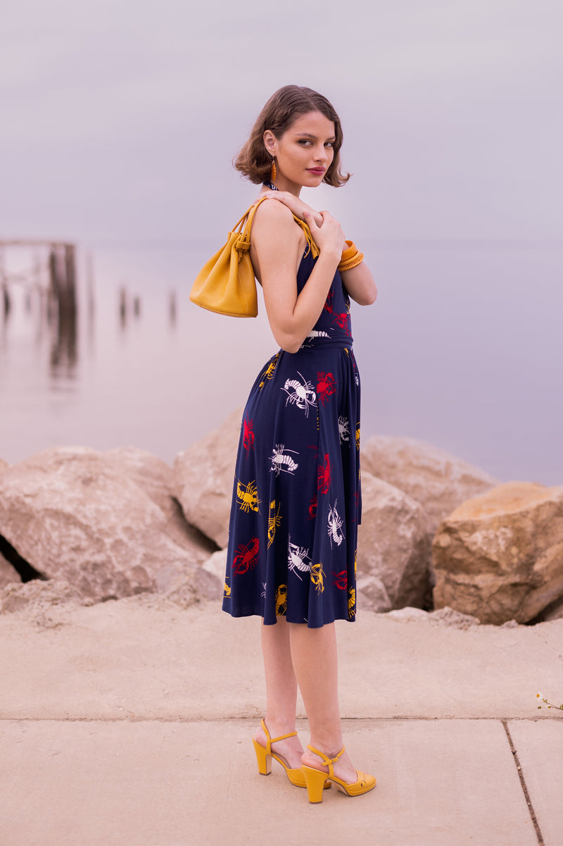 Our High Waist Skirt is a brand staple featuring knee-length or just below 1940s vintage inspired style, a high fitted straight waistband, and pockets in the new Crawfish print, a 1930s 1940s novelty print of red, yellow, and white crustaceans on a deep navy blue background as a nod to Schiaparelli's lobster.