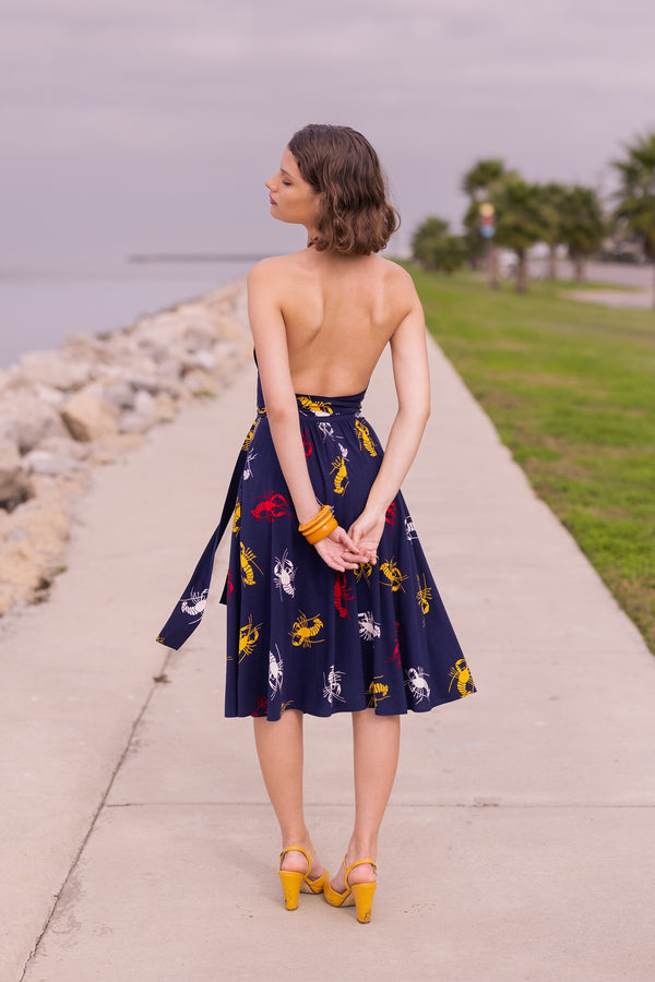Our High Waist Skirt is a brand staple featuring knee-length or just below 1940s vintage inspired style, a high fitted straight waistband, and pockets in the new Crawfish print, a 1930s 1940s novelty print of red, yellow, and white crustaceans on a deep navy blue background as a nod to Schiaparelli's lobster.